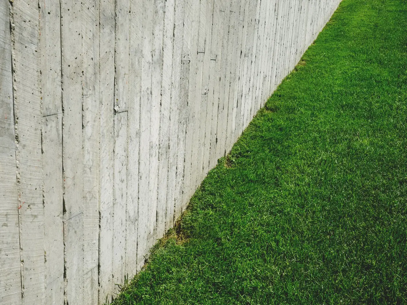 A clean striped lawn beside a fence